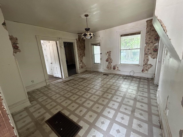 1108 6th St, Beloit, WI 53511 - unfurnished dining area featuring light flooring, baseboards, and a chandelier