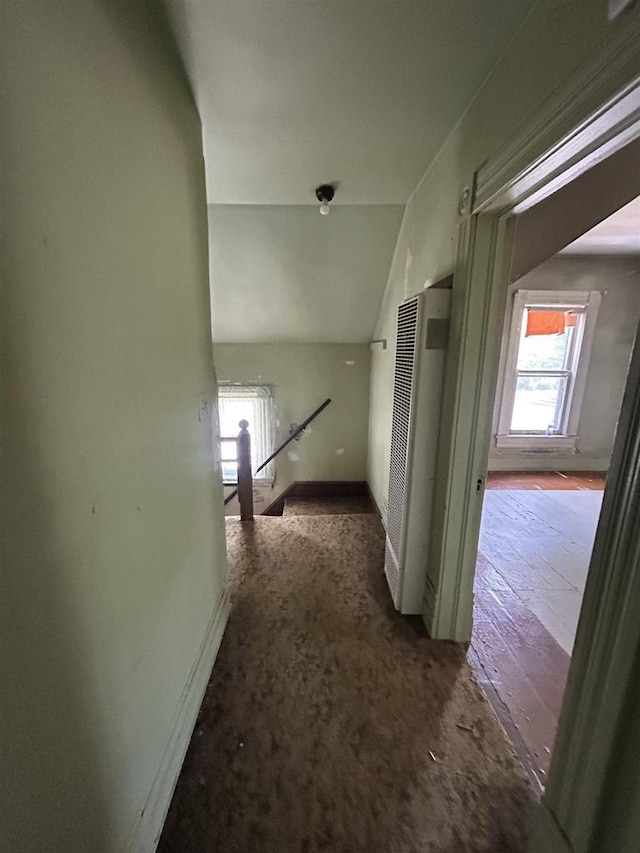 1108 6th St, Beloit, WI 53511 - hall featuring a heating unit, healthy amount of natural light, baseboards, lofted ceiling, and an upstairs landing