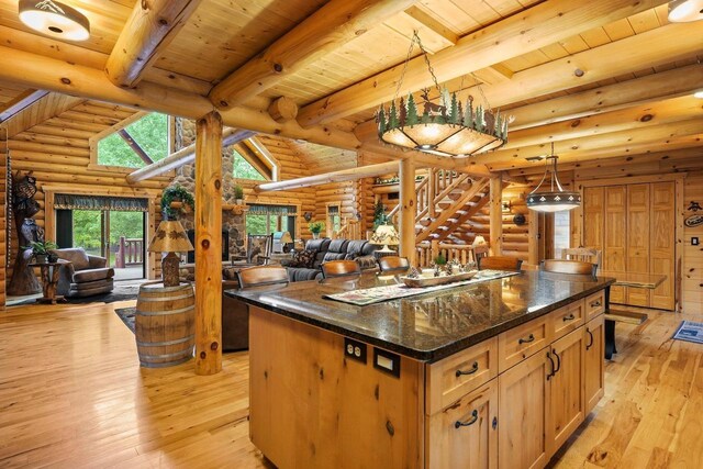 W6034 N Lake Dr, New Lisbon, WI 53950 - kitchen with log walls, open floor plan, wooden ceiling with exposed beams, light wood finished floors, and a center island