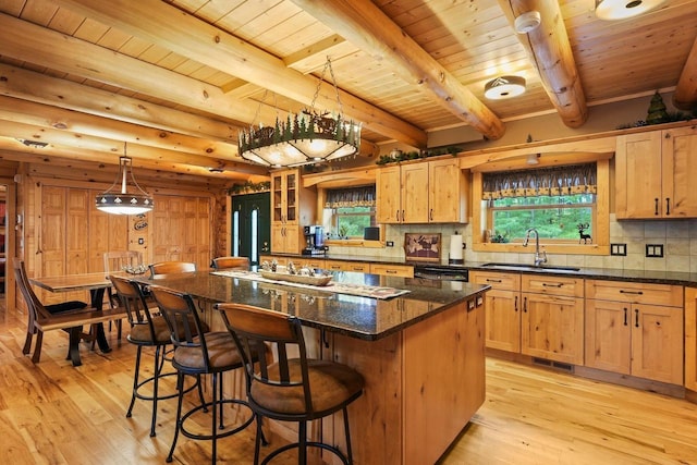 W6034 N Lake Dr, New Lisbon, WI 53950 - kitchen featuring a sink, light wood finished floors, backsplash, a center island, and a breakfast bar