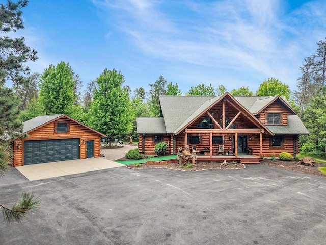 W6034 N Lake Dr, New Lisbon, WI 53950 - log cabin featuring log siding, an outbuilding, a detached garage, and a porch