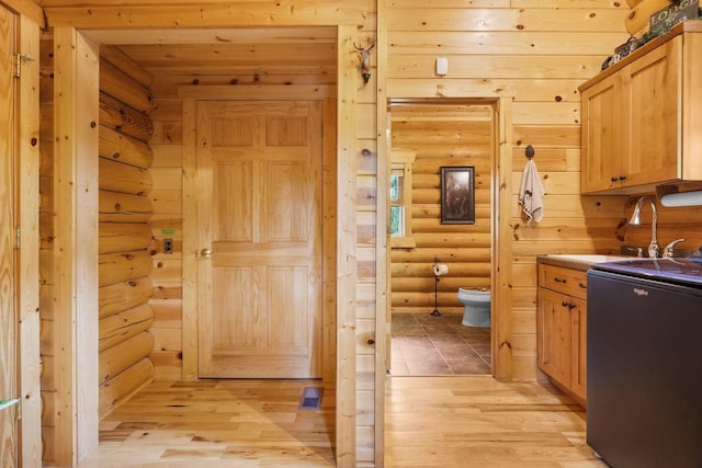 W6034 N Lake Dr, New Lisbon, WI 53950 - bathroom with toilet, log walls, wood finished floors, and a sink