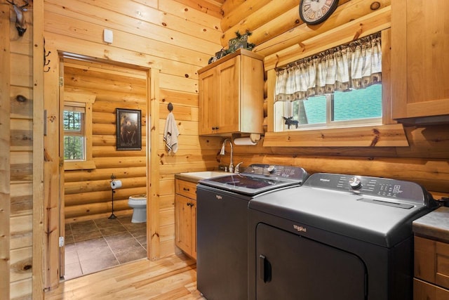 W6034 N Lake Dr, New Lisbon, WI 53950 - laundry area with log walls, separate washer and dryer, cabinet space, and light wood-style floors