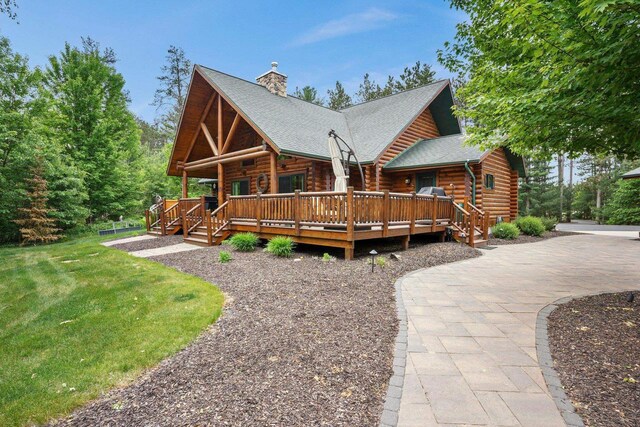 W6034 N Lake Dr, New Lisbon, WI 53950 - rear view of property with log exterior, a chimney, a lawn, and a wooden deck