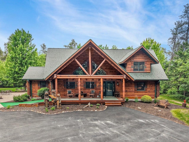 W6034 N Lake Dr, New Lisbon, WI 53950 - log cabin with log siding, roof with shingles, and a porch