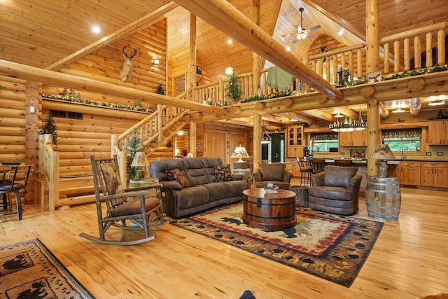 W6034 N Lake Dr, New Lisbon, WI 53950 - living room with high vaulted ceiling, rustic walls, wood ceiling with exposed beams, stairway, and light wood-type flooring