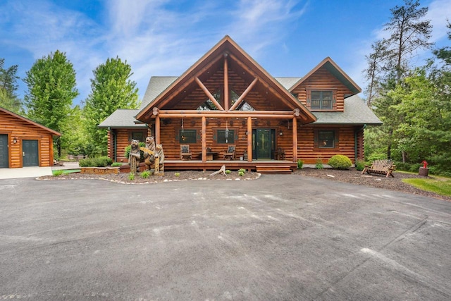 W6034 N Lake Dr, New Lisbon, WI 53950 - log home with log exterior, a porch, and a shingled roof