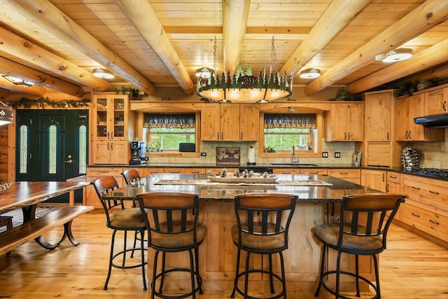 W6034 N Lake Dr, New Lisbon, WI 53950 - kitchen featuring a sink, wood ceiling with exposed beams, light wood-style floors, a kitchen island, and decorative backsplash