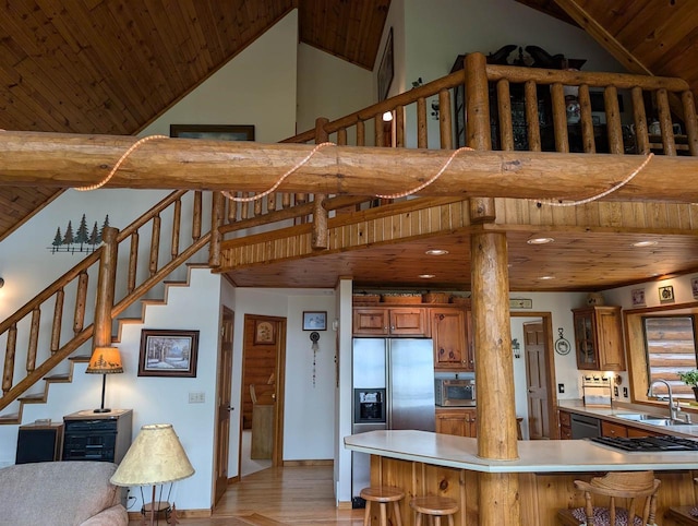 9213 Willow Ln, Fremont, WI 54940 - kitchen with wooden ceiling, a sink, stainless steel appliances, brown cabinetry, and high vaulted ceiling