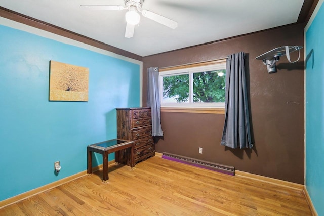 109 County Park Rd, Waupun, WI 53963 - unfurnished bedroom featuring a baseboard radiator, wood finished floors, baseboards, and a ceiling fan