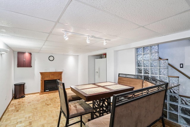 109 County Park Rd, Waupun, WI 53963 - dining area featuring rail lighting, a fireplace, baseboards, and a drop ceiling