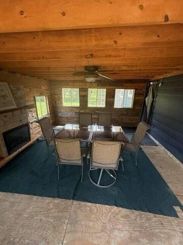 109 County Park Rd, Waupun, WI 53963 - dining space featuring wooden ceiling, a stone fireplace, ceiling fan, and wood walls