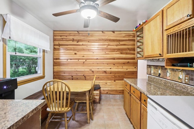 109 County Park Rd, Waupun, WI 53963 - dining room featuring light tile patterned floors, a ceiling fan, and wooden walls