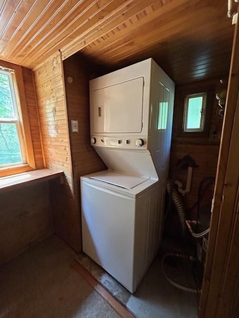 N6812 Eddy Rd, Black River Falls, WI 54615 - laundry area featuring stacked washer and clothes dryer, wood ceiling, and wood walls