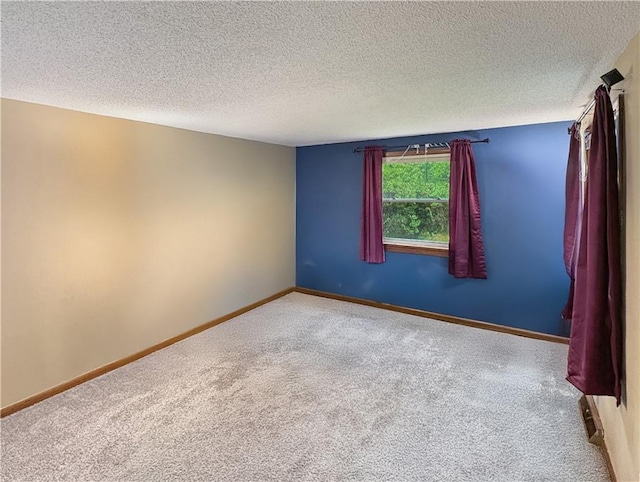 711 Cleveland Ave, Ladysmith, WI 54848 - spare room featuring carpet flooring, a textured ceiling, and baseboards