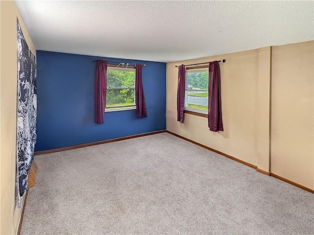 711 Cleveland Ave, Ladysmith, WI 54848 - carpeted spare room with healthy amount of natural light, a textured ceiling, and baseboards