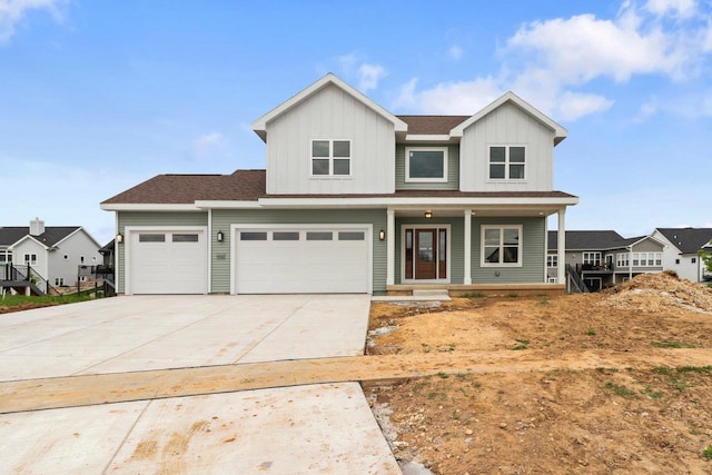 6562 Norski Ct, Windsor, WI 53598 - view of front facade with a porch, concrete driveway, board and batten siding, an attached garage, and roof with shingles