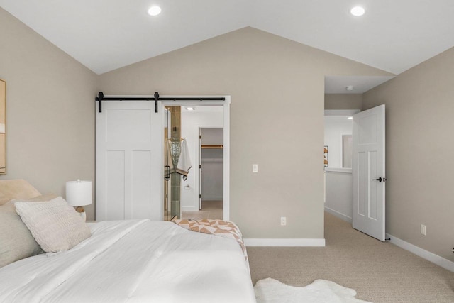 6562 Norski Ct, Windsor, WI 53598 - bedroom with vaulted ceiling, a barn door, baseboards, light carpet, and a walk in closet