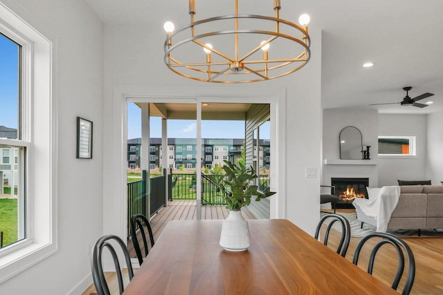 6562 Norski Ct, Windsor, WI 53598 - dining room with wood finished floors, a large fireplace, a chandelier, baseboards, and a ceiling fan