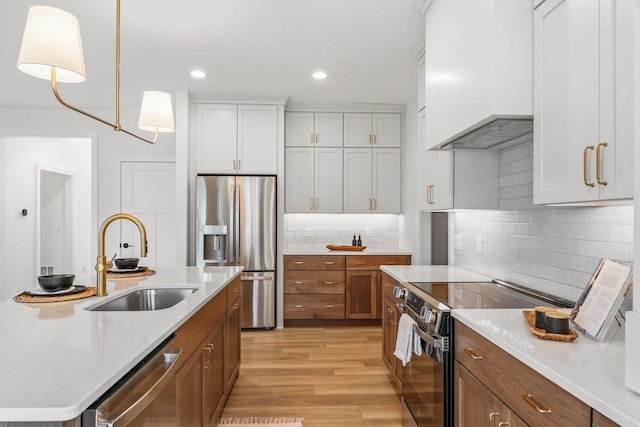 6562 Norski Ct, Windsor, WI 53598 - kitchen featuring stainless steel appliances, a sink, custom range hood, light wood-type flooring, and white cabinetry