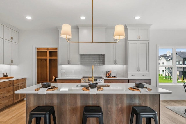 6562 Norski Ct, Windsor, WI 53598 - kitchen with a kitchen breakfast bar, decorative backsplash, a sink, and recessed lighting