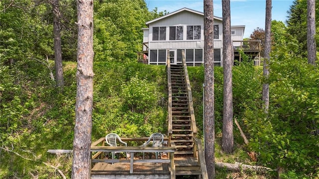 10787 Reynolds Rd, Hayward, WI 54843 - rear view of house featuring stairs, a deck, and a sunroom