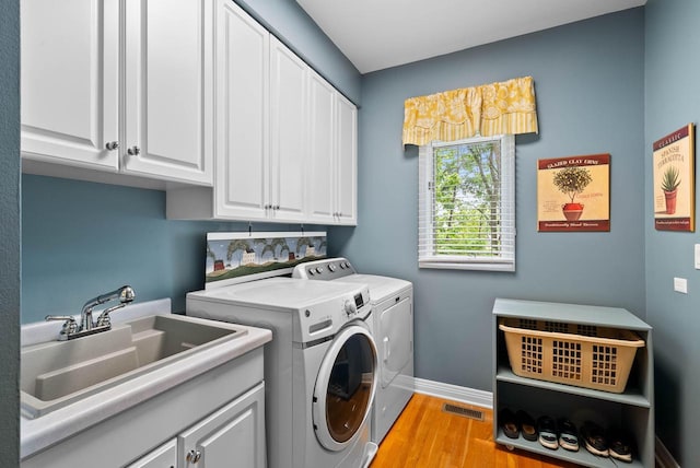 1261 Deer Ct, Lake Geneva, WI 53147 - washroom with washer and clothes dryer, cabinet space, light wood-style flooring, and baseboards