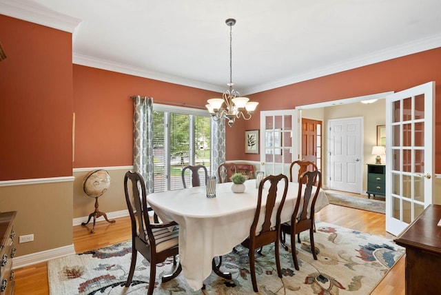 1261 Deer Ct, Lake Geneva, WI 53147 - dining area with french doors, a chandelier, crown molding, light wood-style flooring, and baseboards