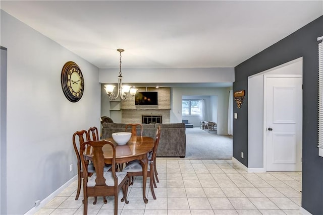 2706 Nimitz St, Eau Claire, WI 54701 - dining space featuring a brick fireplace, light tile patterned floors, baseboards, and a chandelier