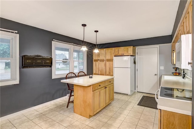 2706 Nimitz St, Eau Claire, WI 54701 - kitchen featuring freestanding refrigerator, light countertops, a kitchen breakfast bar, and light tile patterned floors