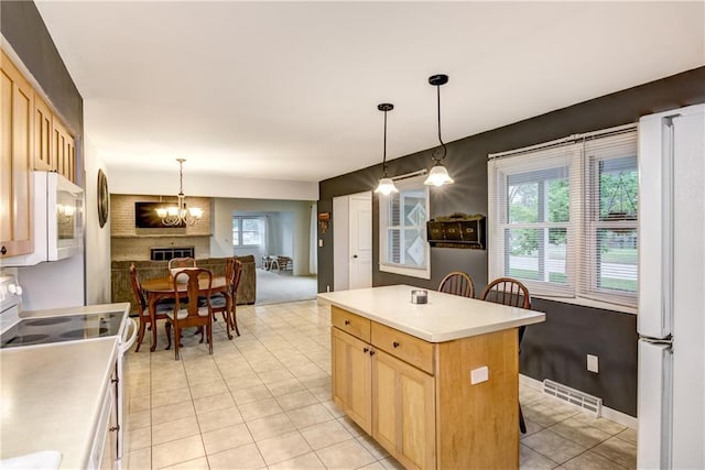 2706 Nimitz St, Eau Claire, WI 54701 - kitchen featuring white appliances, light tile patterned floors, light brown cabinets, and a chandelier
