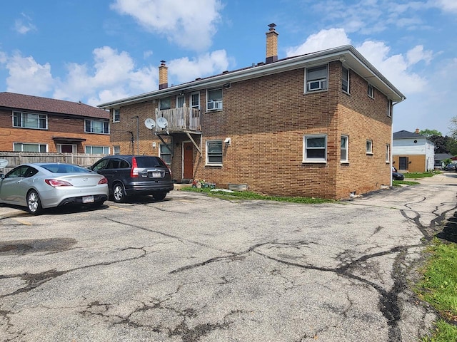 5855 N 83rd St, Milwaukee, WI 53218 - back of property with a chimney, brick siding, and uncovered parking