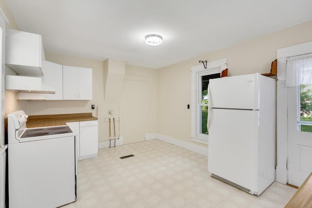 103 First St, Ontario, WI 54651 - kitchen with freestanding refrigerator, washer / dryer, light floors, white cabinetry, and baseboards