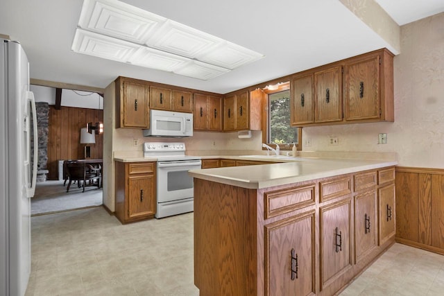 15075 Kings Ridge Ct, Brookfield, WI 53005 - kitchen featuring white appliances, wooden walls, a sink, brown cabinets, and light countertops