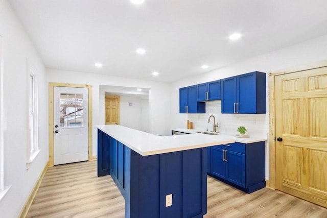 2533 S Austin St, Milwaukee, WI 53207 - kitchen with blue cabinetry, a sink, light wood-style flooring, light countertops, and recessed lighting
