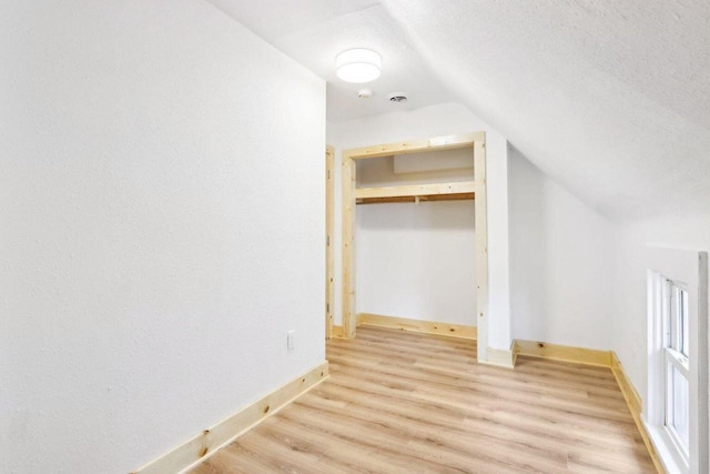 2533 S Austin St, Milwaukee, WI 53207 - unfurnished bedroom featuring vaulted ceiling, light wood-type flooring, baseboards, and a textured ceiling