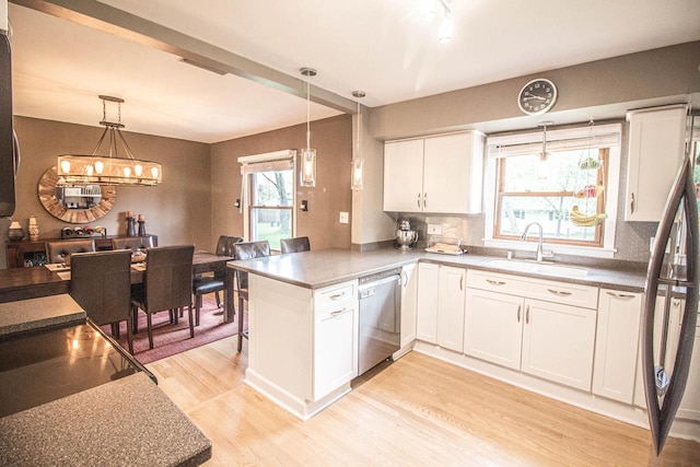8561 N Greenvale Rd, Bayside, WI 53217 - kitchen with appliances with stainless steel finishes, a sink, light wood finished floors, a peninsula, and white cabinets
