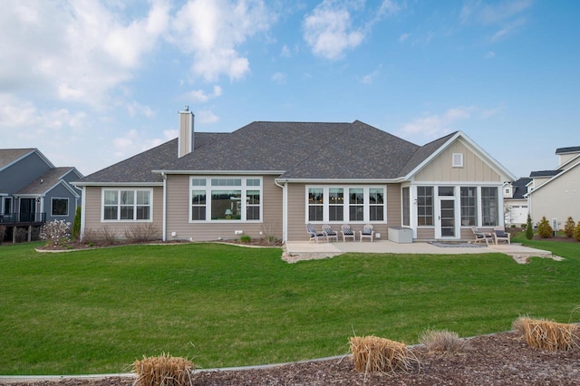 N56W27213 Crispin Ct, Lisbon, WI 53089 - back of house with a patio area, a chimney, a yard, board and batten siding, and a shingled roof