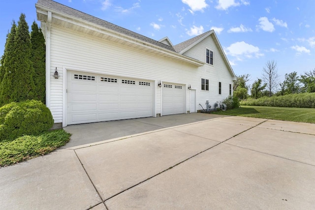 5119 Reynolds Ave, Waunakee, WI 53597 - view of side of home with driveway, an attached garage, a shingled roof, and a yard