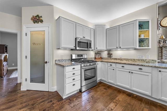 5119 Reynolds Ave, Waunakee, WI 53597 - kitchen featuring stainless steel appliances, light stone countertops, dark wood-style floors, and baseboards
