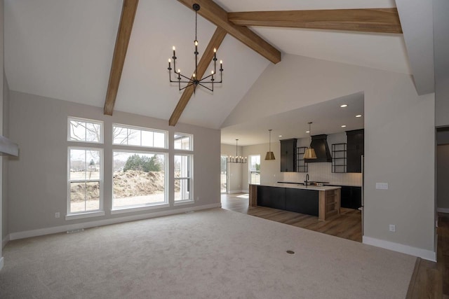 624 Green Bay Rd, Thiensville, WI 53092 - unfurnished living room featuring a chandelier, a sink, beam ceiling, high vaulted ceiling, and baseboards
