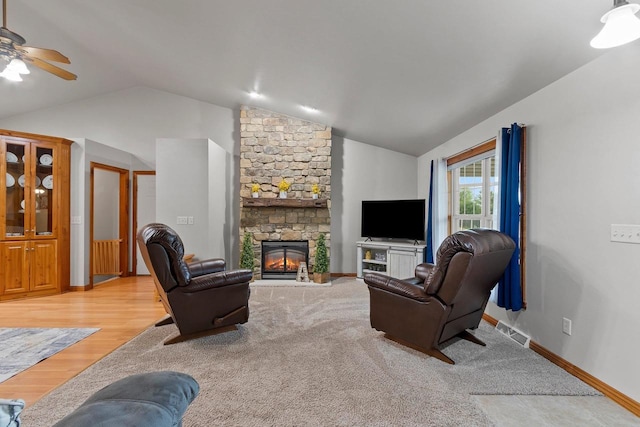 1603 Pine Tree Ln, Luxemburg, WI 54217 - living area featuring vaulted ceiling, a ceiling fan, a stone fireplace, light wood finished floors, and baseboards