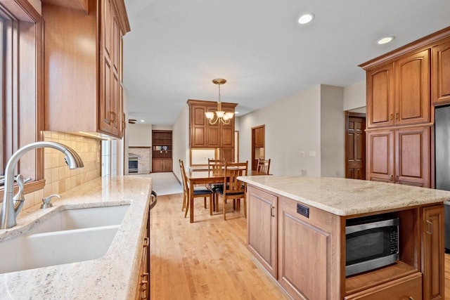 209 E Timberline Dr, Appleton, WI 54913 - kitchen with appliances with stainless steel finishes, a sink, tasteful backsplash, a kitchen island, and light wood-style floors