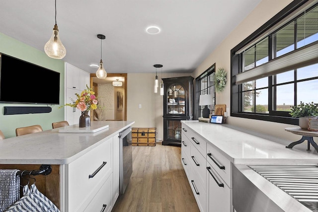 W1691 Fish Creek Rd, Seymour, WI 54165 - kitchen with light wood finished floors, decorative light fixtures, white cabinetry, stainless steel dishwasher, and light stone countertops