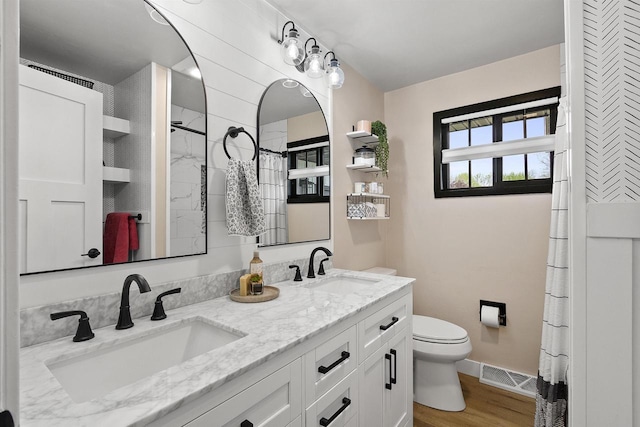 W1691 Fish Creek Rd, Seymour, WI 54165 - full bath featuring toilet, double vanity, wood finished floors, curtained shower, and baseboards
