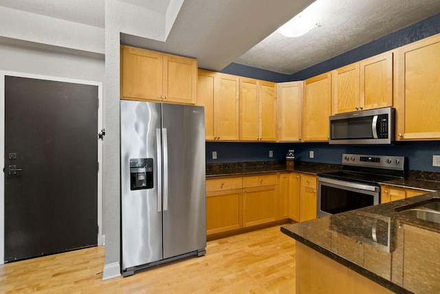 606 W Wisconsin Ave Unit 301, Milwaukee, WI 53203 - kitchen featuring appliances with stainless steel finishes, light wood finished floors, dark stone countertops, and light brown cabinetry