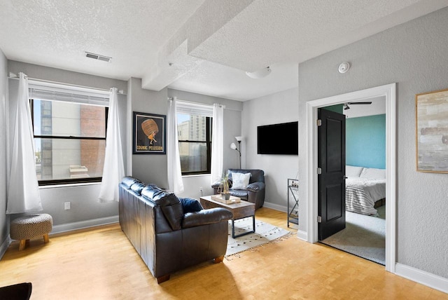 606 W Wisconsin Ave Unit 301, Milwaukee, WI 53203 - living area featuring wood finished floors, a textured ceiling, baseboards, and a textured wall