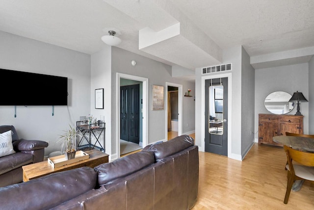 606 W Wisconsin Ave Unit 301, Milwaukee, WI 53203 - living area featuring light wood-style floors, baseboards, and a textured ceiling