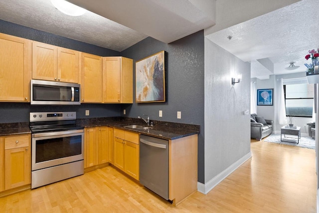 606 W Wisconsin Ave Unit 301, Milwaukee, WI 53203 - kitchen featuring stainless steel appliances, a textured ceiling, light wood-style floors, a textured wall, and a sink