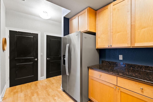 606 W Wisconsin Ave Unit 301, Milwaukee, WI 53203 - kitchen with stainless steel refrigerator with ice dispenser, light wood finished floors, dark stone countertops, and light brown cabinets